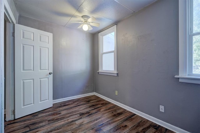 empty room with ceiling fan and dark hardwood / wood-style flooring