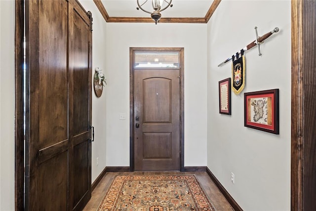 foyer entrance featuring a barn door, dark wood-type flooring, and crown molding