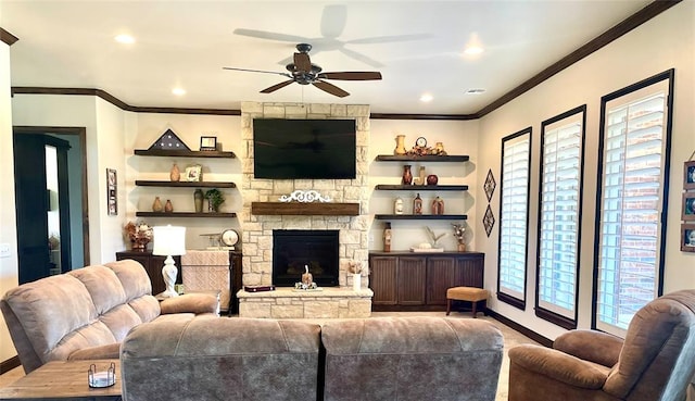 living room featuring a stone fireplace, plenty of natural light, ornamental molding, and ceiling fan