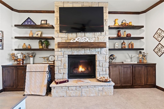 living room with a stone fireplace, crown molding, and light colored carpet