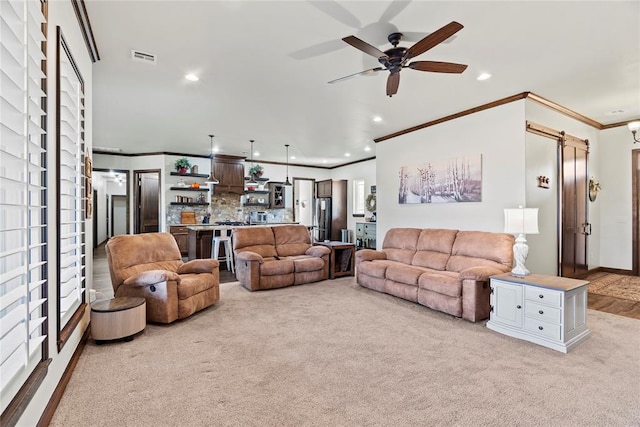 living room with light colored carpet, ceiling fan, and ornamental molding