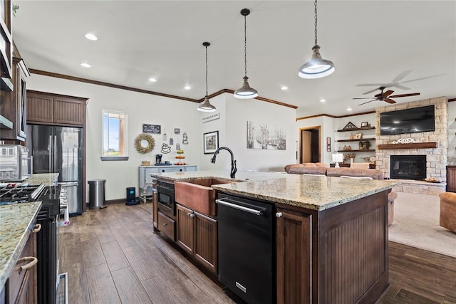 kitchen featuring dark hardwood / wood-style floors, an island with sink, appliances with stainless steel finishes, decorative light fixtures, and dark brown cabinetry