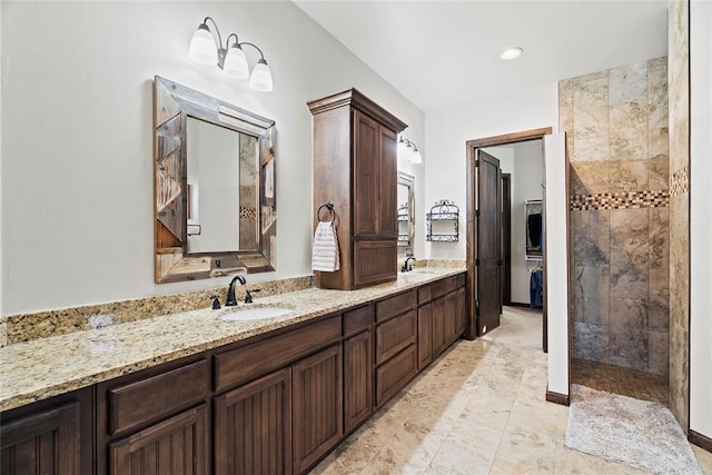 bathroom with vanity and tiled shower