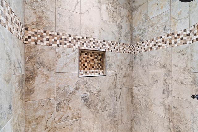 interior details featuring tiled shower