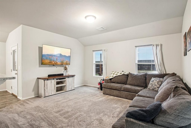 carpeted living room featuring a wealth of natural light and vaulted ceiling