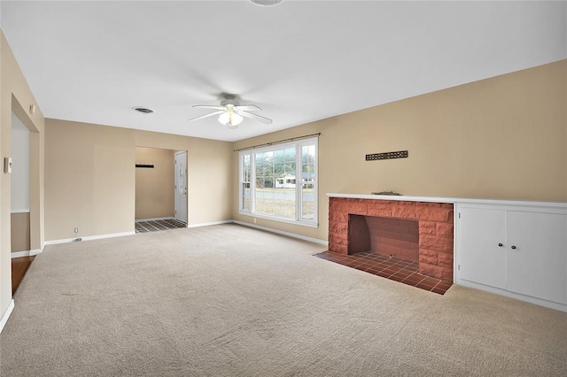 unfurnished living room featuring carpet, ceiling fan, and a brick fireplace