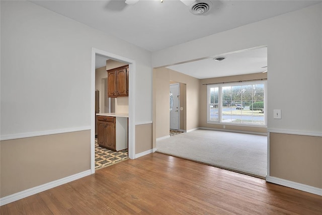 empty room with light hardwood / wood-style flooring and ceiling fan