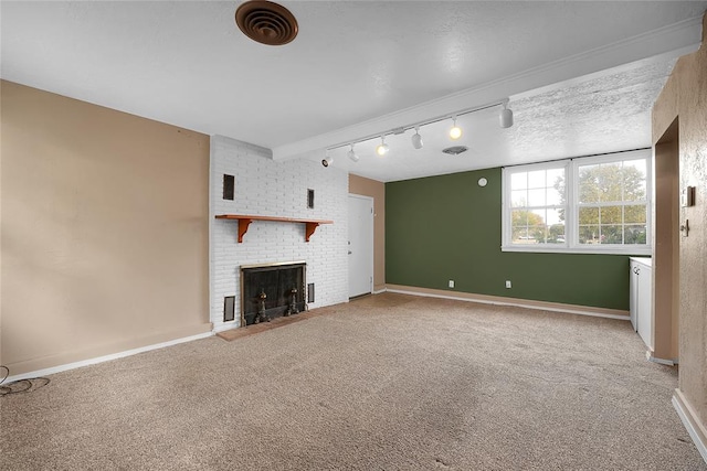 unfurnished living room featuring carpet flooring, a fireplace, a textured ceiling, and track lighting