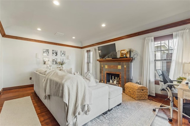 living room with recessed lighting, a tiled fireplace, ornamental molding, wood finished floors, and baseboards