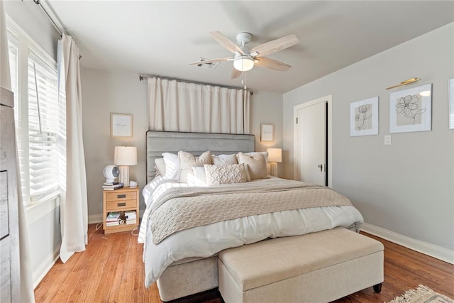 bedroom featuring a ceiling fan, baseboards, and wood finished floors