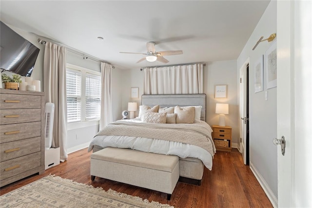 bedroom with dark wood-style floors, a ceiling fan, and baseboards