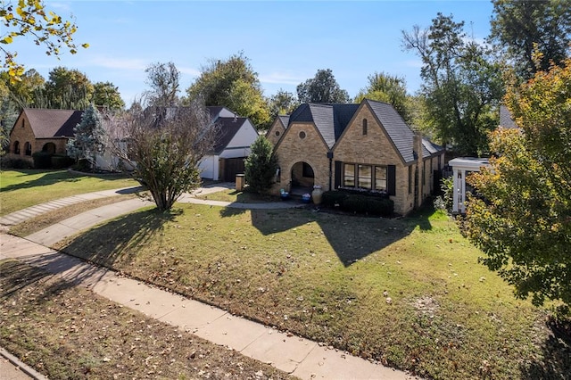 view of front facade with stone siding and a front yard