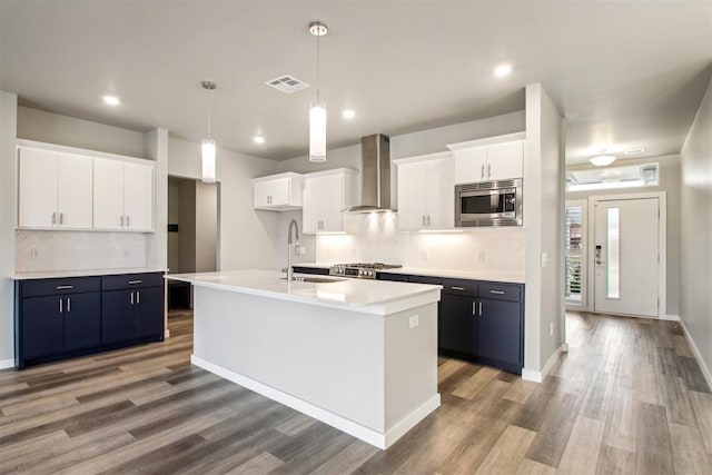 2200 El Cajon St, Edmond, OK 73034 - kitchen with wall chimney range hood, stainless steel microwave, light wood-style flooring, white cabinets, and recessed lighting