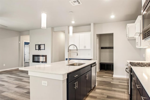 2200 El Cajon St, Edmond, OK 73034 - kitchen with appliances with stainless steel finishes, light wood-style flooring, light countertops, white cabinetry, and decorative light fixtures