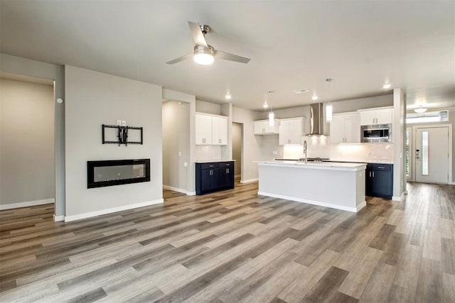 2200 El Cajon St, Edmond, OK 73034 - kitchen with stainless steel microwave, white cabinets, ceiling fan, an island with sink, and recessed lighting