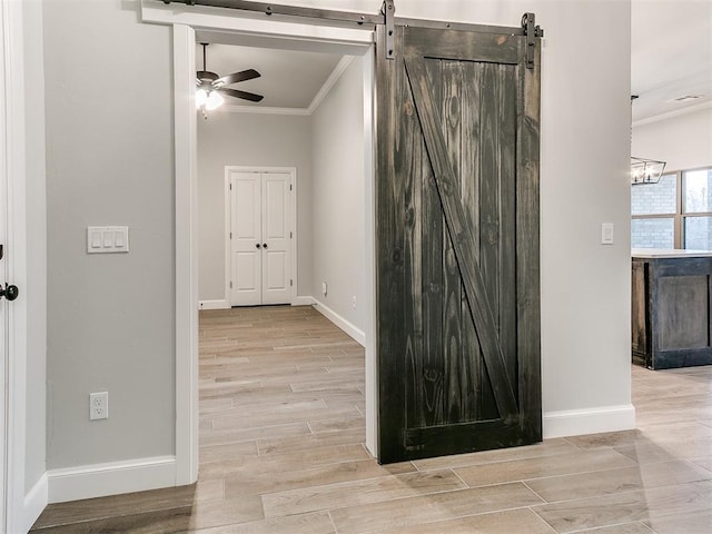 hallway with a barn door and crown molding