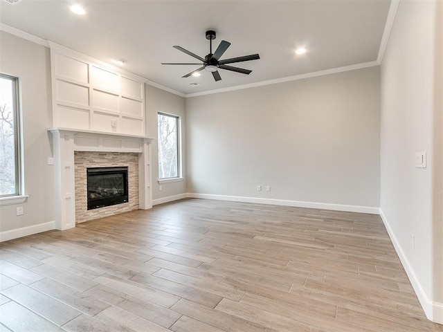 unfurnished living room with ceiling fan, ornamental molding, and a tiled fireplace