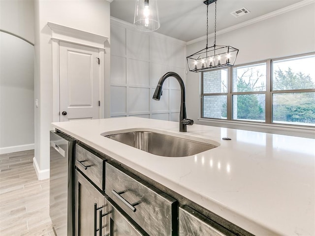 kitchen with light stone countertops, crown molding, sink, dishwasher, and hanging light fixtures