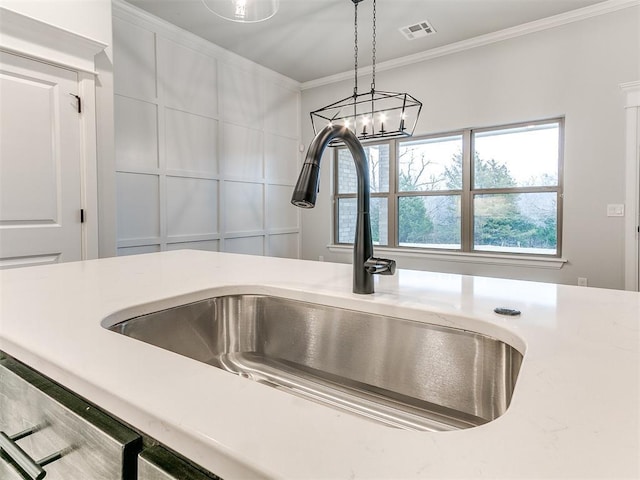 details with white cabinets, pendant lighting, ornamental molding, and sink