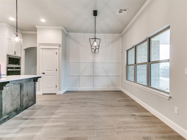 unfurnished dining area with light wood-type flooring and ornamental molding