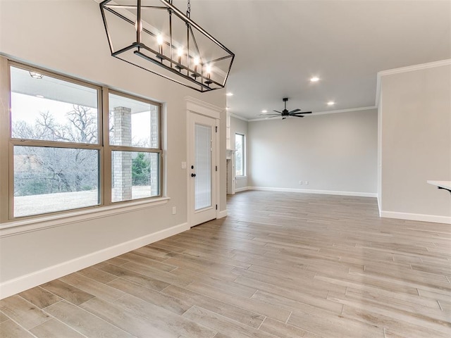 interior space featuring crown molding, light hardwood / wood-style flooring, and ceiling fan with notable chandelier