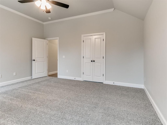 empty room with ceiling fan, carpet floors, crown molding, and vaulted ceiling