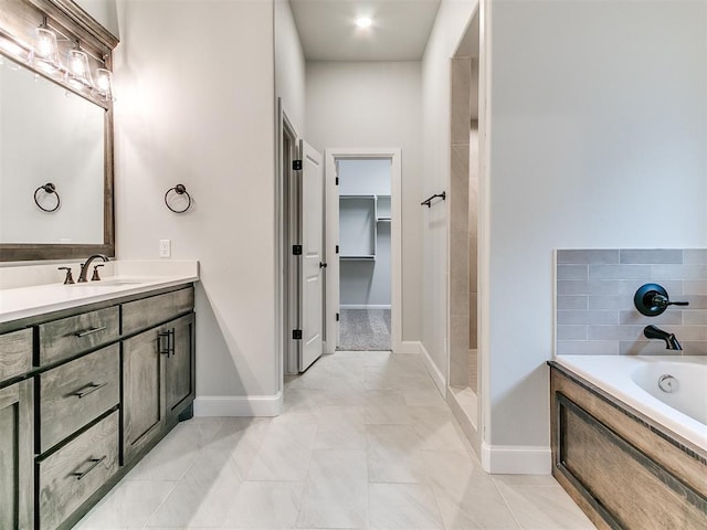 bathroom featuring plus walk in shower, vanity, and tile patterned floors