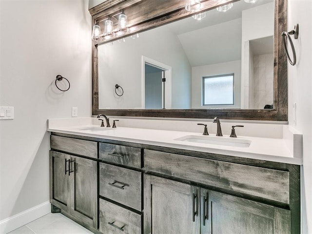 bathroom with tile patterned floors, vanity, and vaulted ceiling