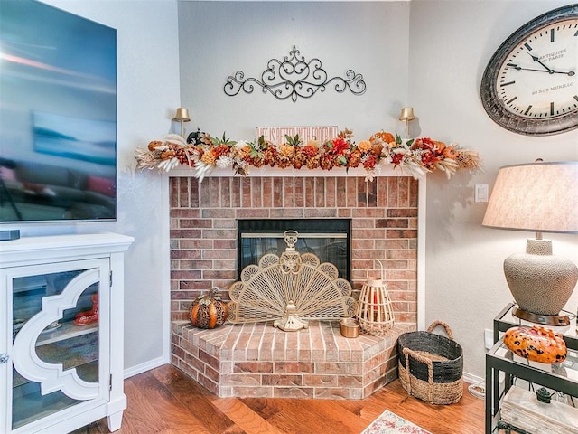 interior details featuring hardwood / wood-style flooring and a brick fireplace