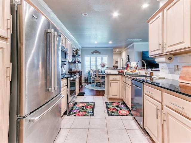 kitchen featuring sink, crown molding, light tile patterned floors, appliances with stainless steel finishes, and kitchen peninsula