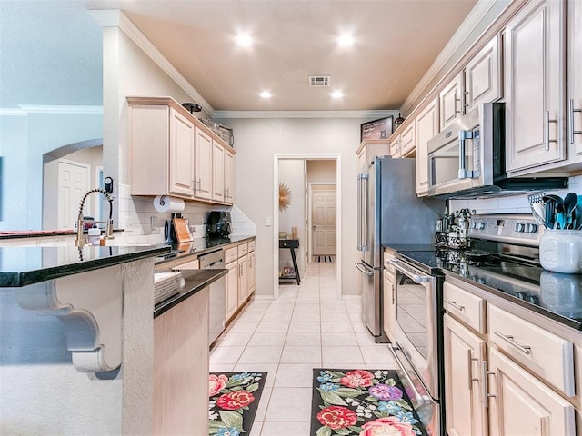 kitchen with stainless steel appliances, light tile patterned flooring, ornamental molding, and backsplash