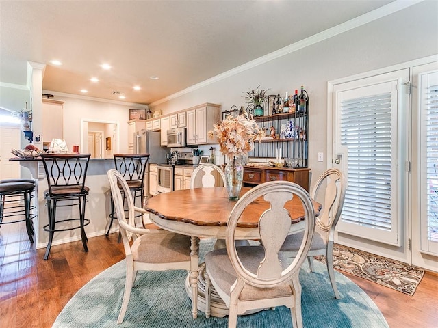 dining area featuring ornamental molding and light hardwood / wood-style floors