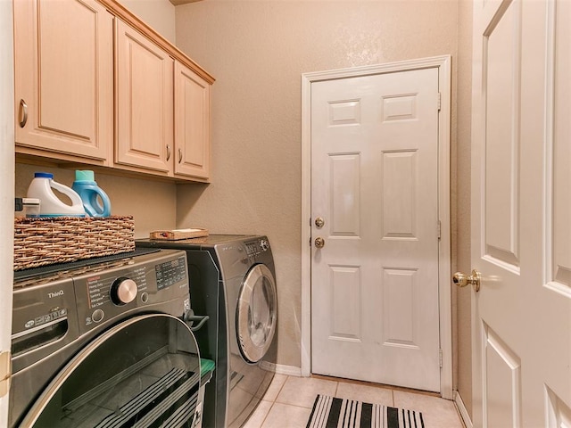 laundry room featuring cabinets, separate washer and dryer, and light tile patterned floors