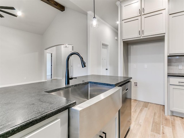 kitchen with dishwasher, white cabinets, lofted ceiling with beams, sink, and decorative light fixtures