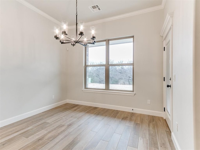 spare room with a chandelier, light wood-type flooring, and ornamental molding