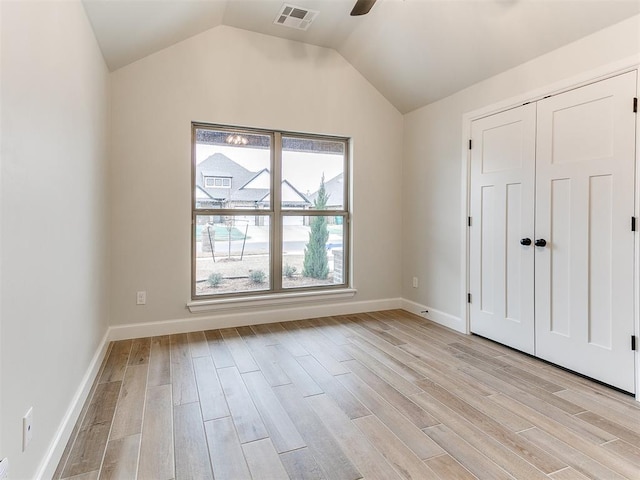 unfurnished bedroom featuring a closet, ceiling fan, light hardwood / wood-style flooring, and vaulted ceiling