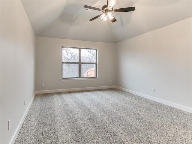 carpeted spare room with ceiling fan and vaulted ceiling