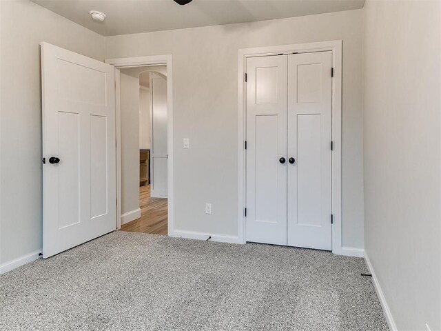 unfurnished bedroom with a closet and light colored carpet