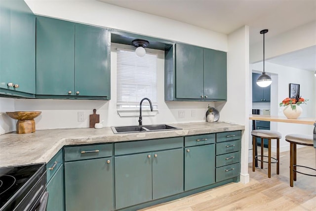 kitchen with pendant lighting, sink, black electric range, green cabinetry, and light wood-type flooring