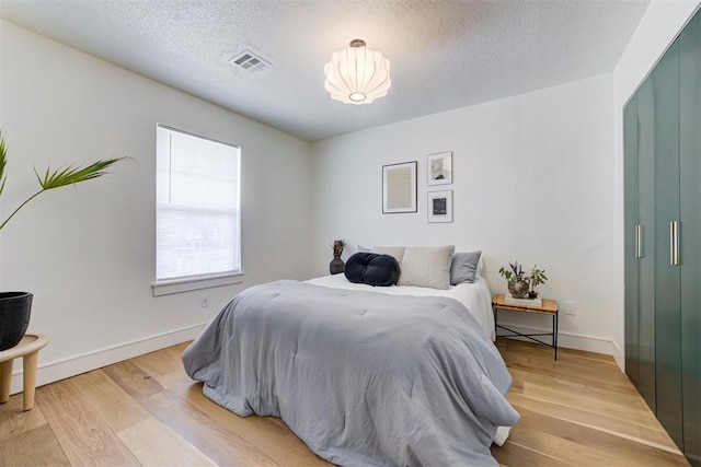 bedroom with hardwood / wood-style floors and a textured ceiling