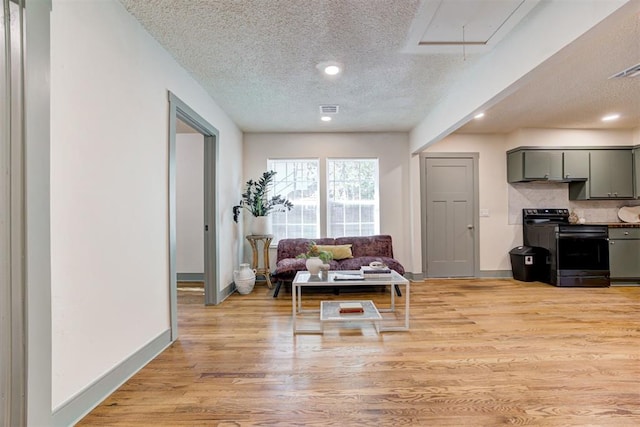 living room with a textured ceiling and light wood-type flooring