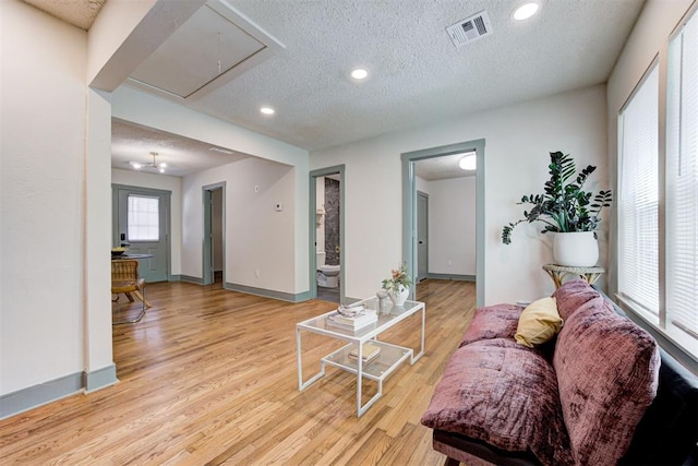 living room featuring light hardwood / wood-style flooring and a textured ceiling