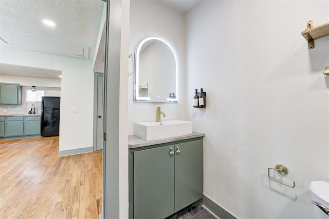 bathroom featuring vanity, hardwood / wood-style flooring, and a textured ceiling