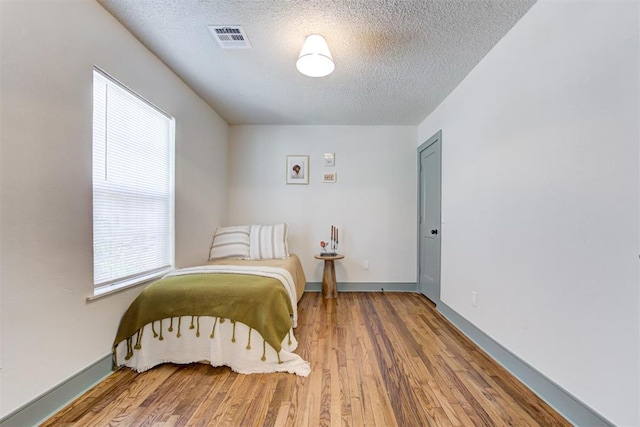 bedroom featuring wood-type flooring and a textured ceiling