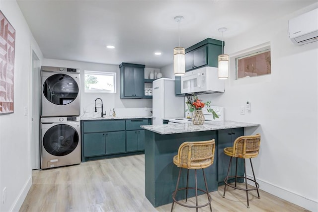 kitchen featuring pendant lighting, white appliances, stacked washer and clothes dryer, a wall mounted air conditioner, and kitchen peninsula