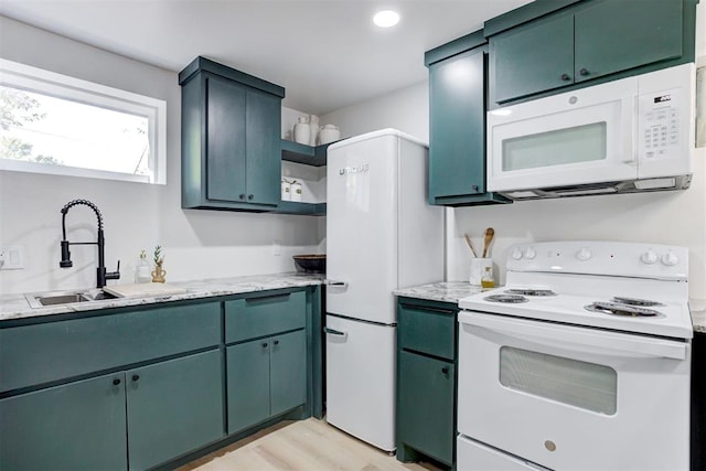 kitchen featuring sink, white appliances, and light hardwood / wood-style flooring