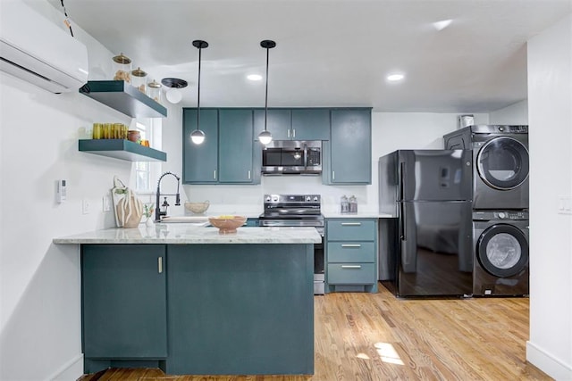 kitchen with pendant lighting, stacked washer and dryer, stainless steel appliances, kitchen peninsula, and an AC wall unit