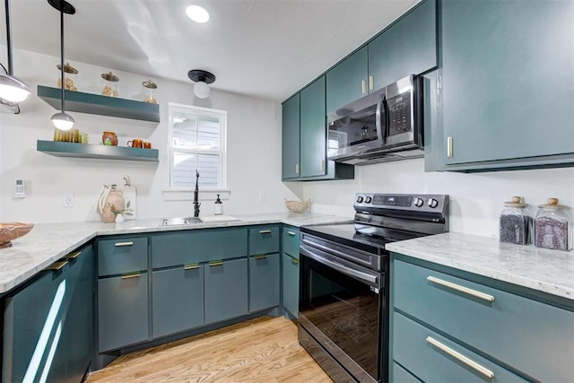 kitchen with appliances with stainless steel finishes, blue cabinets, sink, light stone counters, and light hardwood / wood-style flooring