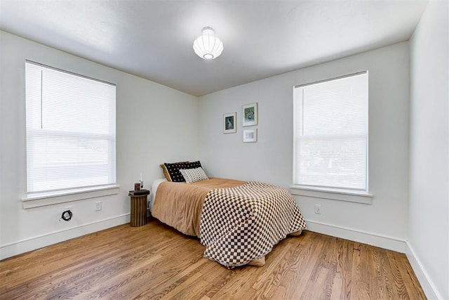 bedroom featuring multiple windows and hardwood / wood-style flooring