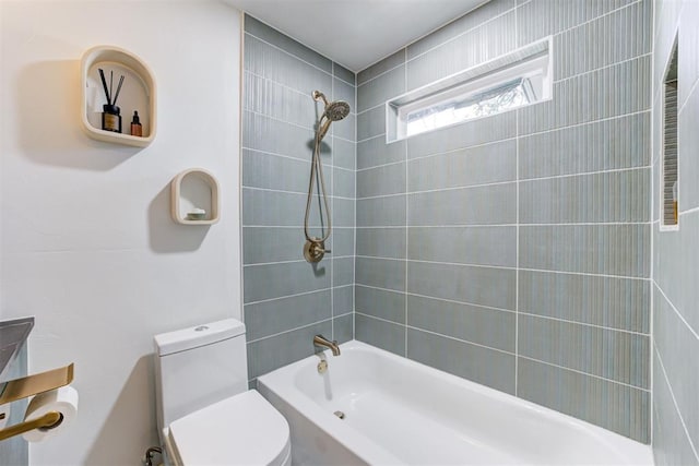 bathroom featuring toilet and tiled shower / bath combo